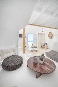 Cette chambre blanche comprend un lit et une table. dans l'établissement Sophia Boutique Hotel, à Oia