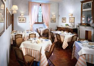 un comedor con mesas con manteles blancos en Villa Il Poggiale Dimora Storica, en San Casciano in Val di Pesa