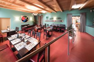 a restaurant with wooden ceilings and tables and chairs at Hotel Masatsch in Caldaro