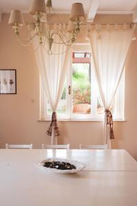 une salle à manger avec une table blanche et une fenêtre dans l'établissement Casa vacanze a Rubbianello, à Monterubbiano