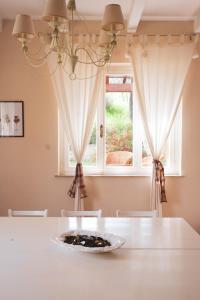 un comedor con una mesa blanca y una ventana en Casa vacanze a Rubbianello, en Monterubbiano
