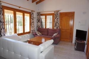 - un salon avec un canapé et une télévision dans l'établissement Muriel House, à Monte Pego
