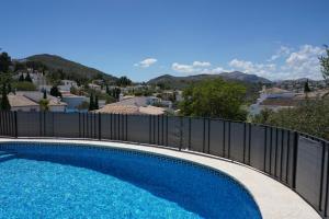 une piscine avec une clôture et des montagnes en arrière-plan dans l'établissement Muriel House, à Monte Pego