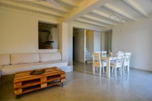 a living room with a couch and a table and chairs at Andros Tessera in Andros