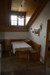Habitación con mesa, sillas y ventana en Mansarde en Cornaiano