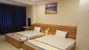 a hotel room with two beds and a window at Sky in Ha Long