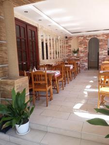a restaurant with wooden tables and wooden chairs at Guest House Perla in Obzor