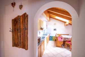a kitchen with an archway leading to a dining room at Cèsa Castlunger in Canazei