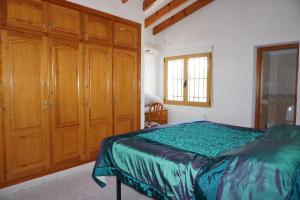 1 dormitorio con armarios de madera y 1 cama. en Muriel House, en Monte Pego 28 fotos más