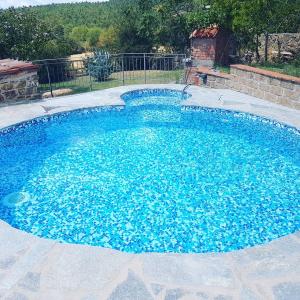 a large pool with blue water in a yard at La Locanda della Picciolana in Sorano