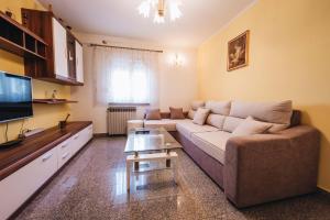 uma sala de estar com um sofá e uma televisão em Apartment Danica em Split