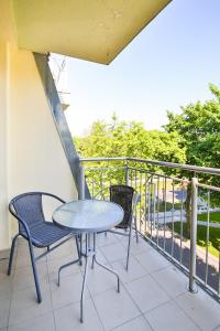 stół i dwa krzesła na balkonie w obiekcie Apartamenty Świnoujście - Róża Wiatrów w Świnoujściu