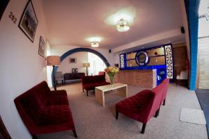 a living room with red couches and a table with flowers at Cooper Hotel Boutique in Cusco