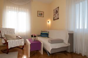 a living room with a bed and a chair and a table at Iva 1, wonderful view of Kvarner Bay in Opatija