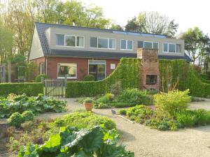 una casa con un jardín delante de ella en B&B Tuin der Zinnen en Rijkevorsel
