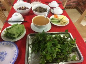a table topped with plates of food and a bowl of soup at Homestay Thanh Long in Cat Ba