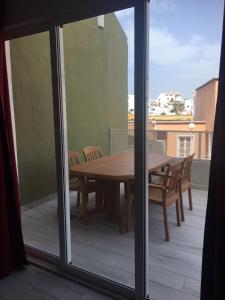 阿德赫的住宿－Bonito apartamento Complejo Orlando，阳台配有桌椅和玻璃窗