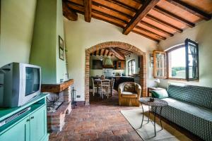 een woonkamer met een tv en een open haard bij Podere Casanuova in San Gimignano