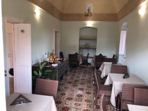 una sala da pranzo con tavoli, sedie e specchio di Dimora Li Cuti a Sannicola