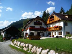 ein großes weißes Gebäude mit Balkon auf einer Straße in der Unterkunft Binderhof in Weisspriach