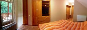 a bedroom with a bed and a dresser with a television at Sunset Beach Apartmanház in Balatonvilágos