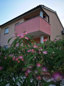 a building with pink flowers in front of it at APARTMENT IVA 2 in Ližnjan