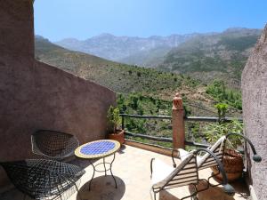 a balcony with a table and chairs and a view at Toubkal Garden in Imlil