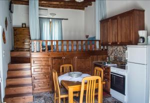 una cucina con armadi in legno, tavolo e sedie di Grandmother's house a Psinthos