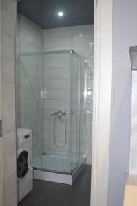 a glass shower in a bathroom with a washing machine at appartamenti premium in Batumi +89 photos