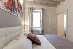 a bedroom with a white bed and a window at De Rustici Apartment in Florence