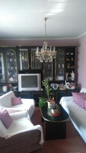 a living room with two white couches and a chandelier at Gerania ház in Vonyarcvashegy