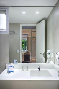 
a bathroom with a sink, mirror and tub at Injoy Lofts Ipanema in Rio de Janeiro
