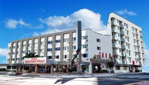 ein großes weißes Gebäude in einer Stadtstraße in der Unterkunft Hotel Gracher Praia in Balneário Camboriú