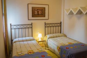 1 dormitorio con 2 camas y una foto en la pared en Apartamento Torcal Écija, en Écija