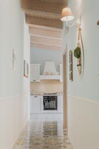 una cucina con pareti bianche e un pavimento con lampada di La Casetta in villa a Santa Maria di Castellabate