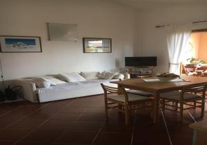 a living room with a white couch and a table at Casa Asparagi in San Teodoro