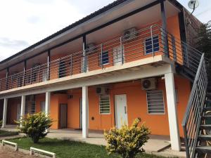 un edificio de color naranja con balcón y escalera en Apart Tierra Sureña en Catriel