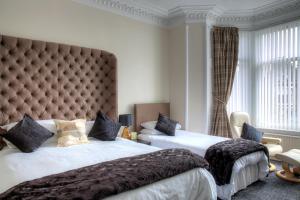 1 dormitorio con 2 camas y cabecero grande en Kildonan Guest House, en Aberdeen