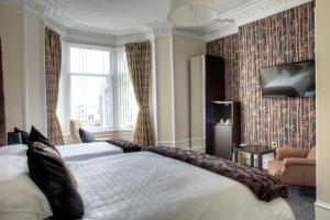 a hotel room with two beds and a television at Kildonan Guest House in Aberdeen