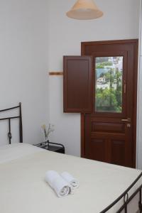 a bedroom with a bed with two rolled towels on it at Villa Zacharo in Skala