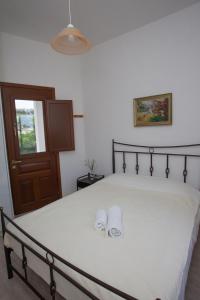 a bedroom with a bed with two slippers on it at Villa Zacharo in Skala