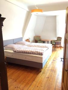 1 dormitorio con 1 cama y sillas en el suelo de madera en Palais-Volkach, en Volkach