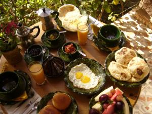 una mesa llena de alimentos para el desayuno y zumo de naranja en Villa Zagora Ma Villa au Sahara en Zagora