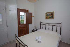 a bedroom with a bed with two slippers on it at Villa Zacharo in Skala