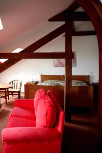 a living room with a red couch and a bed at Punta Del Corno Agriturismo in San Felice del Benaco