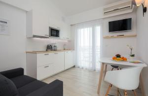 a white kitchen with a table and a couch at Apartments Panorama in Trogir