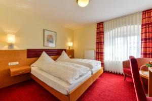 um quarto de hotel com uma cama grande e uma secretária em Hotel Sixt em Rohr