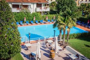 a swimming pool with a pool table and chairs at Hotel Porto Azzurro in Sirmione
