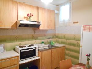 a kitchen with wooden cabinets and a sink and a microwave at Agnes Rooms in Kinion