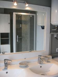 La salle de bains est pourvue d'un lavabo et d'un grand miroir. dans l'établissement Le Pouliguen, au Pouliguen